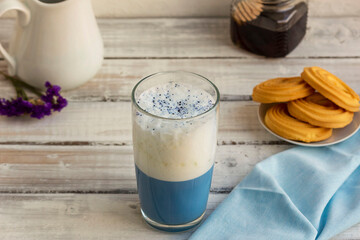 Blue matcha tea in a glass of latte on the table. Place for text. Horizontal orientation. Selective focus.