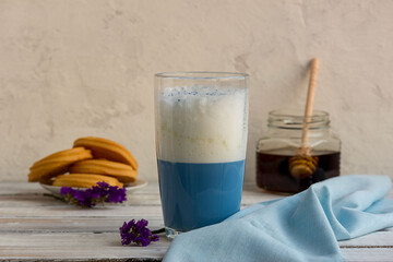 Blue matcha tea in a glass of latte on the table. Place for text. Horizontal orientation. Selective focus.