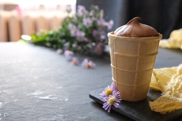 On a dark background, a cup of chocolate ice cream.