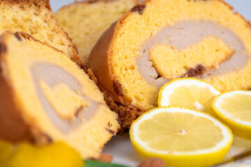 Bizcocho de limón y brazo gitano relleno de crema de café y vainilla con rodajas de limón con enfoque selectivo.