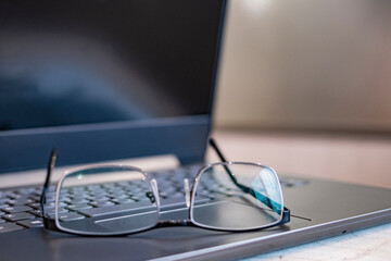 Beautiful glasses on the laptop. Out of focus. Blurred