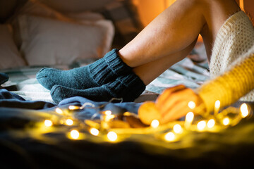 cozy Christmas at home woman in wool socks in bed eating cookies