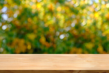 wooden table in the garden, beautiful blurred natural landscape in the background, long panorama, the concept of a cozy autumn mood, blank for the designer
