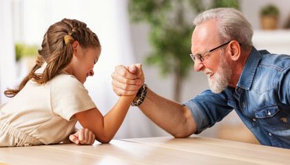 Grandfather arm wrestling with granddaughter. - obrazy, fototapety, plakaty