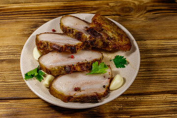 Baked pork belly in a plate on wooden table