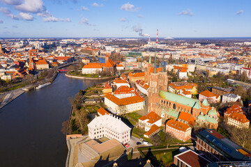 Fototapeta na wymiar Aerial view of historical part of Wroclaw city - Ostrow Tumski on Oder river overlooking Gothic spires of medieval Cathedral and Collegiate Church in spring, Poland
