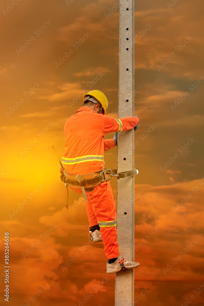 Poster an electrician in a safety suit is climbing a light pole to go up and check availability of the elec