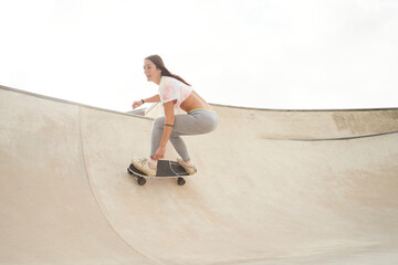Girl rides a skateboard in the bowl of a skatepark