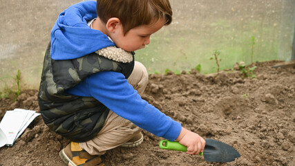 Child with a small shoulder blade in a greenhouse