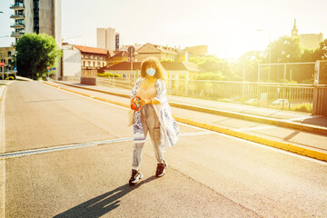 Young mixed race woman wearing mask walking outdoor - Multiethnic girl outdoor strolling wearing...
