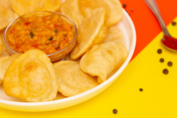 Indian cuisine. Tortillas rays with boiled vegetables and lentils. Yellow - red background, side view.
