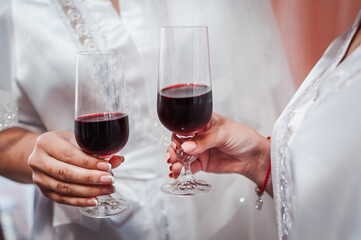 glasses with red wine in the hands of girls