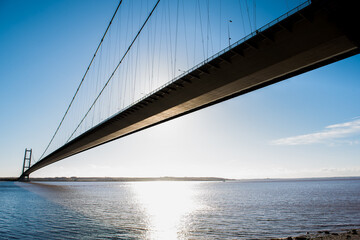 A large suspension bridge in bright blue skies and sunlight 