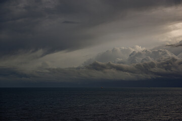 Stormy skies over the sea with varying colours and cloud formations