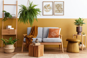 Stylish scandinavian interior of living room with design grey velvet sofa, cube, furniture, plants,...