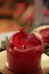 Blown out red christmas candle with smoke. Closeup of a red smoking candle.