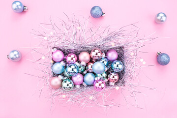 Christmas composition. Christmas balls, pink and blue decorations on pink background. Christmas gift box with Christmas balls. Flat lay, copy space, top view. Winter holidays, New Year. Merry Christma