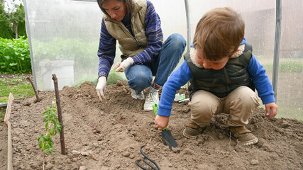 The child is digging in the greenhouse in the greenhouse