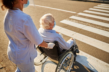 Female social worker taking helpful caregiver older male