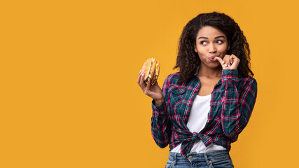 Happy African American Lady Holding Burger At Studio
