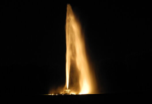 Fountain at night. The water jet from a meter-high water fountain at night is illuminated from below.
