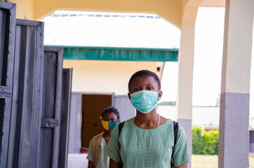 Fototapeta na wymiar two young african students wearing face mask to prevent them from the outbreak in the society as the return to school.