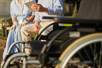 Image of wheelchair in front of elderly man and woman medicine worker