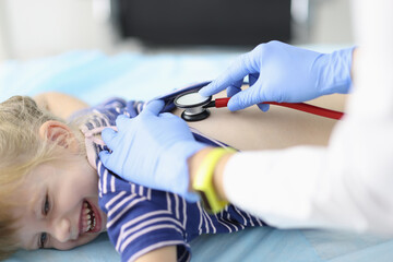 Doctor listens to little girl breathing with stethoscope. The first signs of pneumonia in children...
