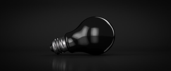 Black electric light bulb on a black background. With copy space