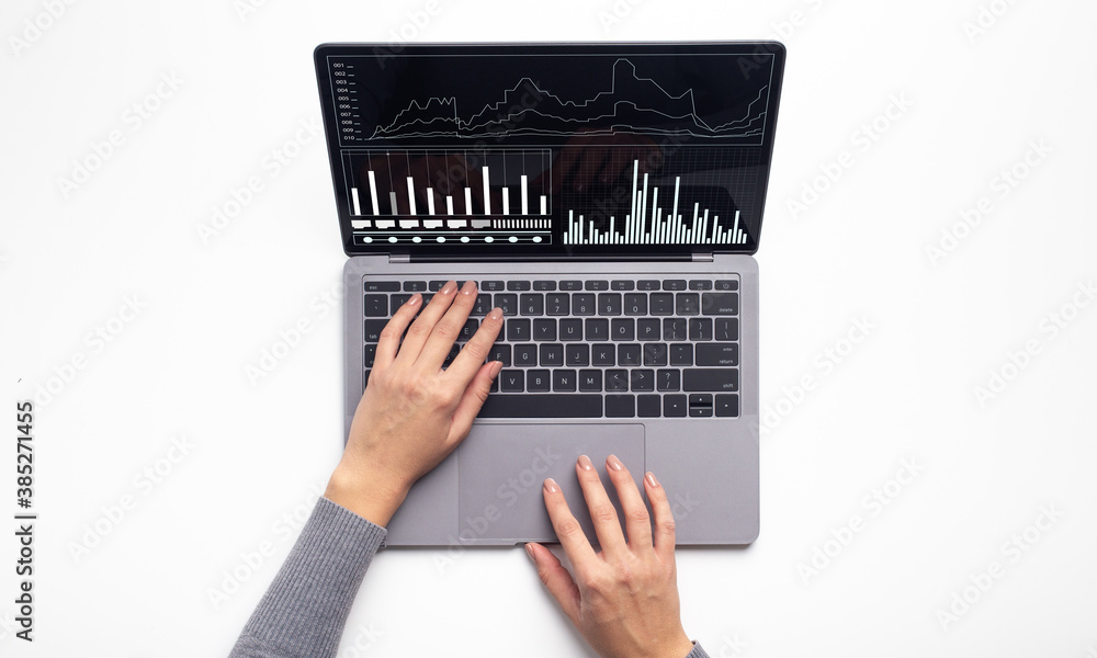 Aufkleber female hands typing on laptop computer with business financial graphics on screen