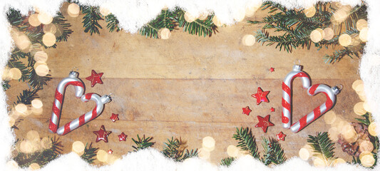 Festive celebration Christmas / xmas background template / holiday card - Top view from frame made of snow, fir branches, candy canes, stars and bokeh lights on rustic wooden table texture
