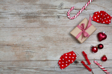 Christmas ornaments and face masks on wooden background, top view