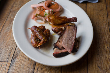 Barbecue catering platter with variety of meats. Traditional Texas BBQ: Beef brisket, beef ribs, pork ribs, sausage links, black pepper roasted chicken, and turkey served with homemade sauce.