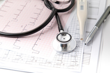 Blue Stethoscope on electrocardiogram (ECG) chart paper. ECG heart chart scan isolate on white. Healthcare insurance and medical background