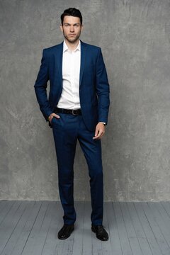 full length of handsome man wear blue suit isolated on grey background