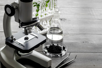 Microscope and plants on a table in scientific laboratory. Agriculture concept
