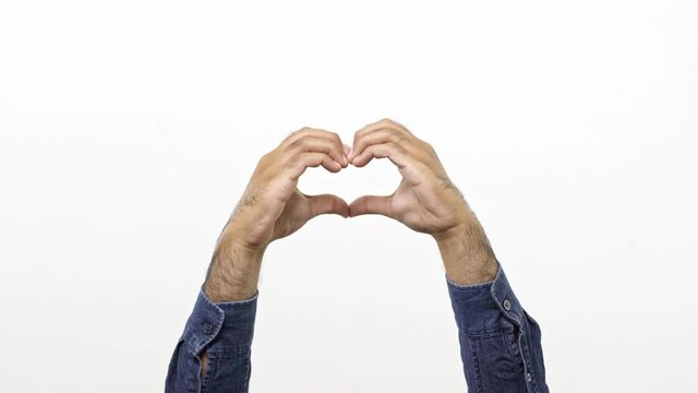 Close up cropped man showing shape heart with hands heart-shape sign isolated on white background in studio. Copy space place for text promotional content. Advertising area workspace mock up. 4K Resol