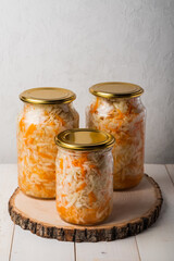 Fototapeta na wymiar Homemade sauerkraut in a glass jar on a gray background. Fermented product Marinated cabbage.The best natural probiotic.