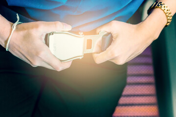 Woman wearing a safety Seat belt on the plane. (vintage color tone)