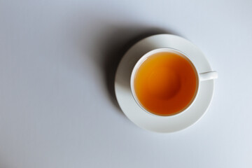 Obraz na płótnie Canvas Top view of a cup of hot tea with copy space.Hot tea is in a white glass placed on a white background. There is space for the message. White background.