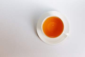 Obraz na płótnie Canvas Top view of a cup of hot tea with copy space.Hot tea is in a white glass placed on a white background. There is space for the message. White background.