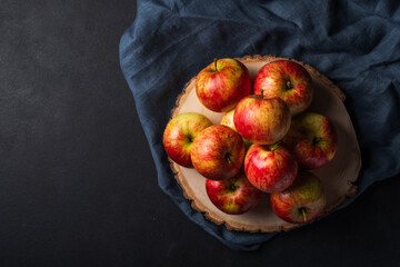 Red apples on a wooden board on a dark background. Natural product. Healthy eating.