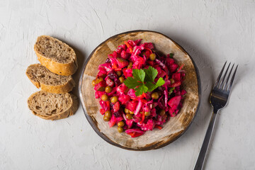 Beet salad in bowl. Healthy detox salad with beetroot, potato, carrot, pickles. Vegetarian vegetable vinegret in a round clay plate on a white background with copy space