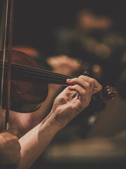 Close frame for the hand of a violinist of a symphony orchestra