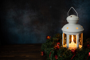 white lantern with a burning candle and fir branches © Ольга Гагарова