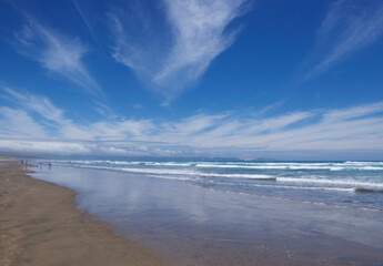 Beautiful panoramic scenic view to the ocean with woman figure in the water. New Zealand