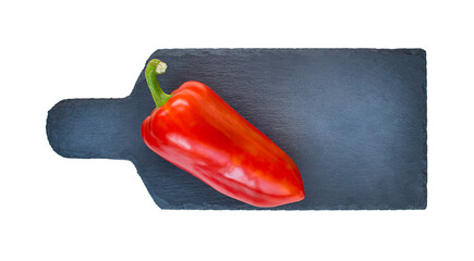 red pepper on a cutting black board on a white background