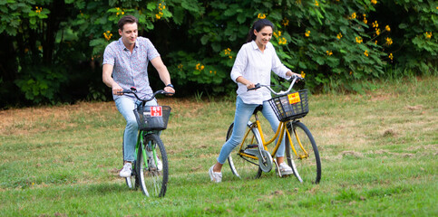 Fototapeta premium Romantic couple in love concept. happy couple riding a bicycle at the summer park