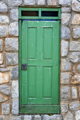 Vintage wooden door on a rustic cabine stone wall