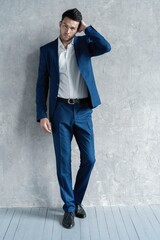 full length of handsome man wear blue suit isolated on grey background